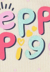 Tessuto di crema chiara con lettere colorate in rilievo che scrivono "Peppa Pig" in rosa, blu e giallo, con riflessi di glitter e piccoli motivi.