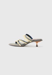 Denim slidesandal med tre gule frynset stropper, en lett spiss tå og en metallisk kittenhæl. Flat såle med dekorativ søm.