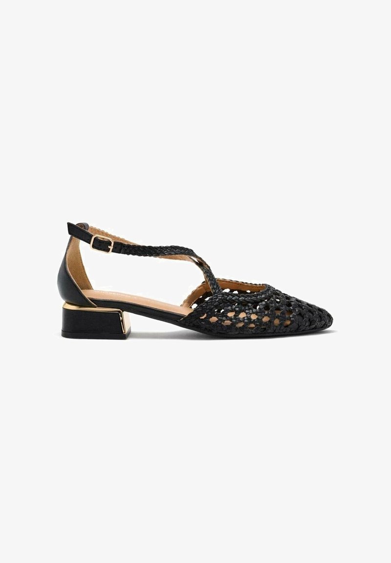 Chaussure plate tissée noire avec bout pointu, bride en T, boucle à la cheville et talon bas carré avec accent doré.