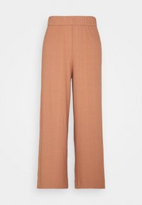 Pantalons large en terre cuite en tissu texturé et côtelé. Dotés d'une taille élastique et d'une coupe droite sans poches visibles.