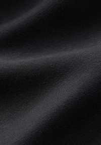 Černá texturovaná látka s jemným žebrovaným povrchem, ukazující měkkost a záhyby, vhodná pro různé textilní aplikace.