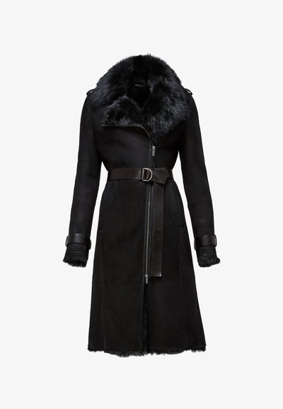 Mustat shearling-takit, joissa on leveä turkiskaulus, vetoketjukiinnitys, vyötärölle sidottu vyö ja turkilla vuoratut hihansuut. Sileä pinta ja tyylikäs muotoilu.