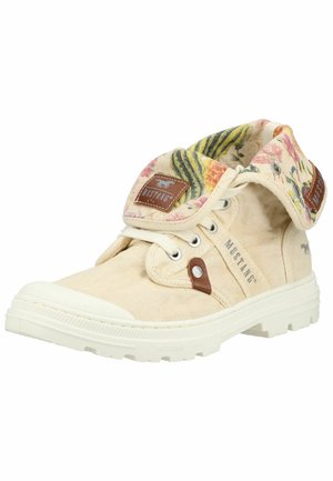 Beżowy tenisówki na wysokiej podeszwie z płótna z białą podeszwą, kołnierzem z motywem kwiatowym, sznurówkami oraz naszywkami i napisem marki Mustang.