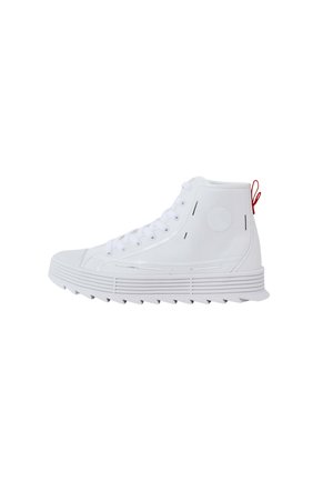 Sneaker bianca high-top con suola spessa scanalata, allacciatura frontale, dettagli di cuciture sottili e linguetta rossa sul tallone.