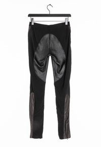 Schwarze Hose mit einem strukturierten lederähnlichen Einsatz auf der Rückseite, meshseitlichen Akzenten und einem Reißverschluss am Saum, in schmaler, taillierter Passform.