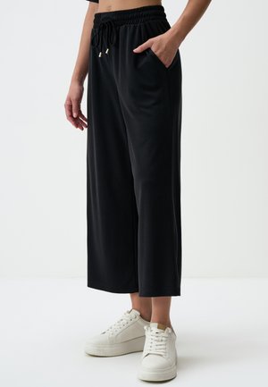 Pantaloni neri a gamba larga realizzati in morbido tessuto, con una vita elasticizzata dotata di cordoncino, tasche laterali e una texture liscia.