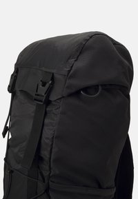 Crna ruksak izrađena od izdržljive tkanine, strukturiranog oblika, s poklopcem na vrhu, podesivim trakama i bočnom petljom za pričvršćivanje.