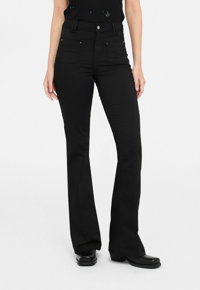 Zwarte flare jeans met een hoge taille, voorzien van een knoopsluiting, voorzakken en subtiele glanzende hardware accenten. Glad stoftextuur.