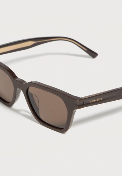 Lunettes de soleil rectangulaires marron foncé avec verres teintés et logo Giorgio Armani sur la branche, présentées sur une surface blanche.