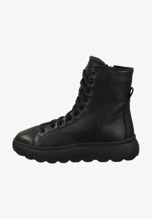 Schwarze Leder-Stiefeletten mit runder Zehenpartie, Schnürung vorne und einer dicken, strukturierten Gummisohle in Schwarz. Mit Metallösen und einer Zuglasche.