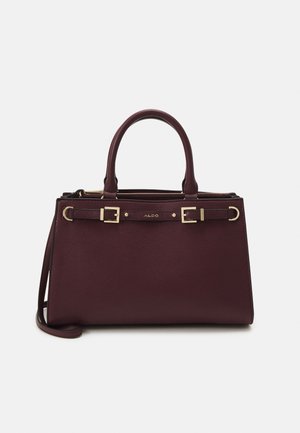 Donker bordeauxrode leren handtas met dubbele bovenhandvatten, verstelbare voorstraps met gouden gespen en een subtiel merklogo.