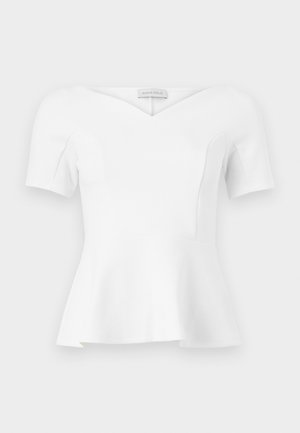 Haut blanc à manches courtes avec basque, encolure en cœur et taille cintrée, étiquette "Anna Field" visible à l'intérieur du col.