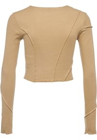 Beige lyhyet hiharat toppi, joka on valmistettu ribattusta materiaalista. Ominaista kaarevat saumat ja raakahaitarit. Tekstuurin aine näyttää pehmeältä ja joustavalta.