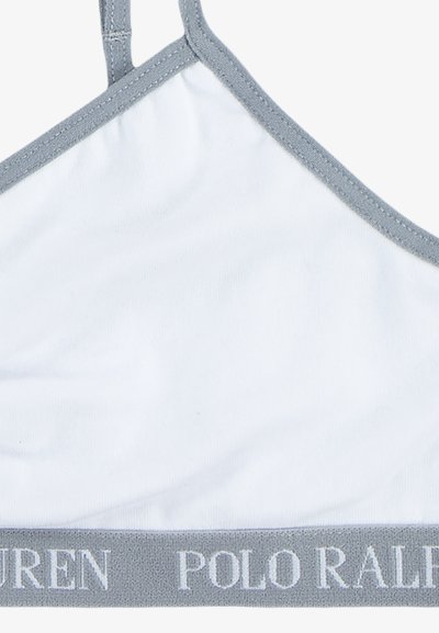 Bela trikotna braletka z svetlo sivo elastično naramnico, na kateri je v kontrastni beli barvi napis "POLO RALPH LAUREN".