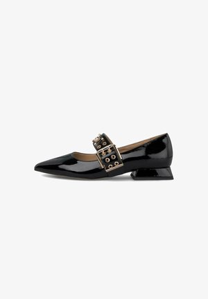 Zapato de charol negro con punta afilada, una tirante ancha con herrajes dorados y remaches, y un tacón bloque para soporte.
