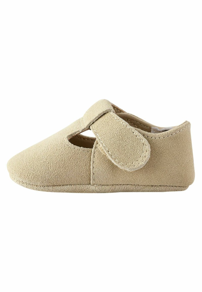 Beige mokkasiner i suedede med utskjæringsdesign og borrelåsrem. Rundt tå og myk tekstur, egnet for innendørs bruk.