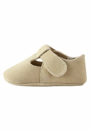 Chaussure bébé en daim beige avec une bride à scratch et une petite ouverture latérale pour un enfilage facile.