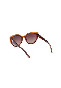 Gafas de sol carey con una amplia forma de ojo de gato, lentes marrones en degradado, grueso marco y delgadas varillas negras con un sutil detalle de marca.
