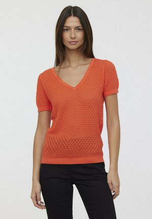 Pull à manches courtes en V couleur orange vif, avec un motif texturé en diamant, un col et un ourlet côtelés, et une silhouette ajustée.