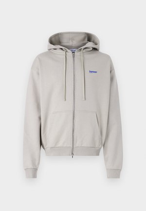 Light gray zip-up hoodie made of soft fabric, featuring a kangaroo pocket, drawstring hood, and blue embroidered logo on the chest.