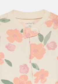 Blumiger Einteiler in Creme, mit großen rosa und helllila Blumen sowie grünen Blättern. Druckknopfverschluss am Kragen. Größe 6 Monate.