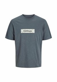 Šedé tričko s krátkým rukávem vyrobené z jemné tkaniny s texturovaným povrchem. Obsahuje obdélníkovou bílou štítek s textem "Jack & Jones" a květinovým vzorem.