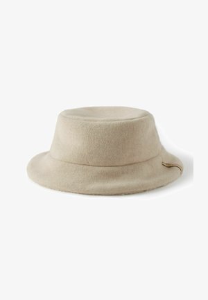 Beige filthatt med vid brätte, formad krona och ett sydd band med en liten accentetikett på sidan.