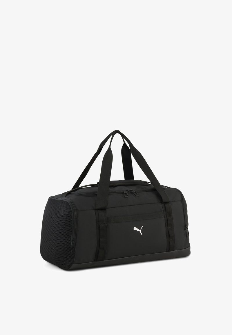 Sort Puma-duffeltaske med dobbelte håndtag, lynlåslommer og netlomme på siden, vist på hvid baggrund.