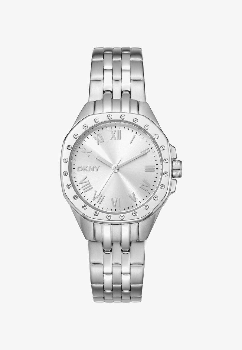 Montre DKNY argentée avec un boîtier rond, des marqueurs en chiffres romains, un cadran texturé et des accents ressemblant à des diamants entourant la lunette. Bracelets en métal reliés.