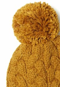 Musztardowożółta dziana czapka z grubo strukturalnym splotem i puszystym pomponem na górze. Wykonana z miękkiego i ciepłego materiału przypominającego wełnę.