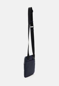 Borsa messaggera navy realizzata in tessuto liscio, con chiusura a zip e tracolla nera regolabile per un facile trasporto.
