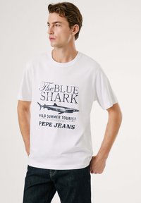 Balta medvilninė marškinėliai su atspausdinta grafika, vaizduojančia ryklį, ir užrašu "THE BLUE SHARK WILD SUMMER TOURIST" nuo Pepe Jeans.