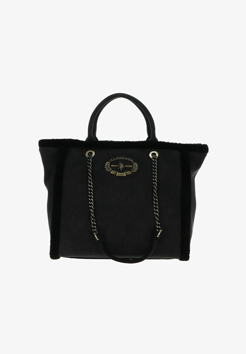 Sac cabas noir avec bordure en fausse fourrure, ferrures métalliques, doubles poignées supérieures et un badge logo proéminent sur le devant. Présente des accents en chaîne.