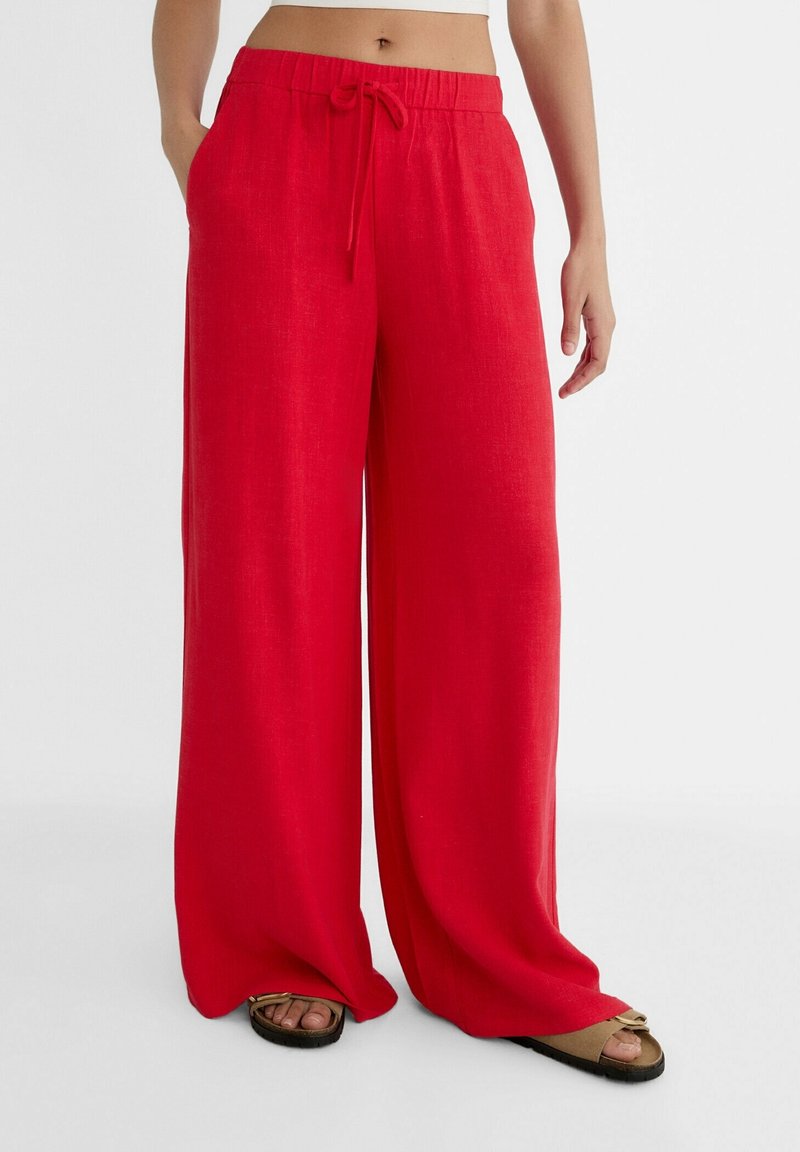 Rote, weit geschnittene Hosen aus leichtem Stoff, mit einem elastischen Bund und Kordelzug sowie knielangen Säumen.