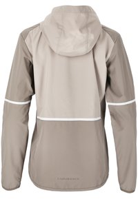 Lätt beige sportjacka med huva. Har vita accentstolar över ryggen och axlarna, slät textur och en figurnära design.