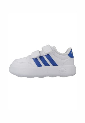Zapatilla blanca para niño pequeño con rayas azules de Adidas, dos tiras de velcro, suela acolchada y lengüeta trasera azul con logo.