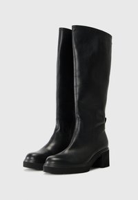 Kniehoge zwarte leren laarzen met een gladde afwerking, blokhak en subtiele stiksels. Rond neus en stevige rubberen zool.