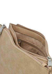 Bolso bandolera de ante beige con múltiples compartimentos con cremallera y forro de cuero suave. Acentos en hardware plateado y textura suave.