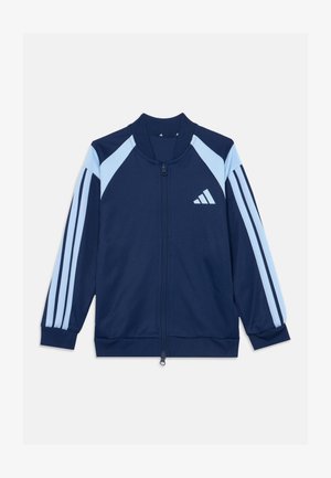 Veste de sport bleu marine à fermeture éclair avec des bandes bleu clair sur les manches et les panneaux d'épaule, avec un logo Adidas blanc sur la poitrine.
