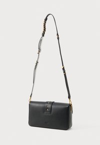 Μαύρη δερμάτινη τσάντα χιαστί με ορθογώνιο σχήμα, που διαθέτει απαλή υφή, χρυσά αξεσουάρ και μια διακοσμητική ζώνη με καρφιά.