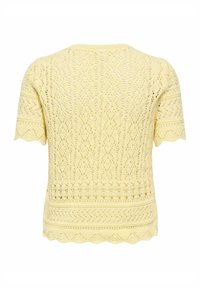 Haut jaune à manches courtes en maille avec des motifs de dentelle complexes et des bords festonnés sur les manches et l'ourlet, vu de dos.