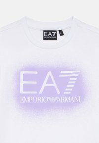 Biele tričko s okrúhlym výstrihom, s gradientnou fialovou grafikou "EA7 Emporio Armani" na prednej strane.