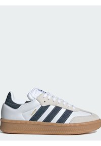 Fehér sneaker szürke és tengerészkék csíkos textil panelekből, velúr orral, gumírozott talppal és három jellegzetes fehér csíkkal az oldalon.