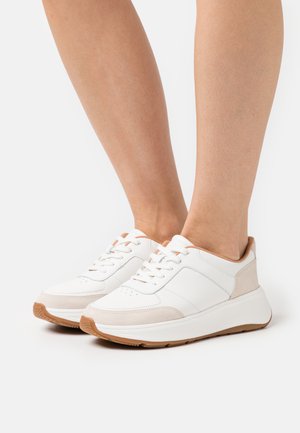Witte leren sneakers met beige suède accenten, platte veters en een gevoerde zool. Heeft perforaties op de neus voor ademend vermogen.