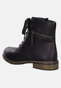 Bottine noire en cuir avec un laçage à l'avant, fermeture éclair sur le côté, bout rond et semelle en caoutchouc texturé ; arbore un logo en relief sur le côté.