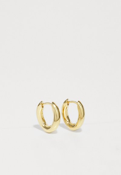 Guld hoops øreringe med et buet, chunky design. Glat metallisk finish, åbne ender for nem påsætning, og subtil glans forbedrer deres udseende.