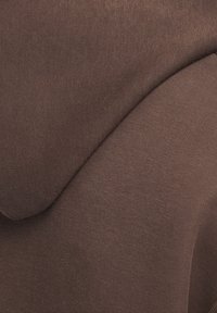 Hoodie brun en tissu doux, avec une texture lisse, une coupe décontractée et un col rond. Pas de motifs ni de matériels visibles.