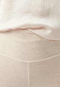 Šviesiai rudos elastingos kelnės iki juosmens su minkšta tekstūra. Juosmuo yra lygus, o šoninėse dalyse matoma subtili siūlių detalė.