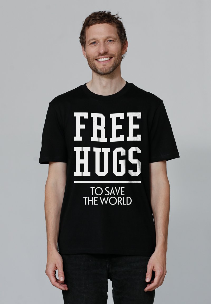 Zwarte T-shirt met korte mouwen met opvallende witte tekst die "FREE HUGS" en "TO SAVE THE WORLD" zegt, met een relaxed fit en ronde hals.