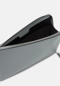 Graue Lederbörse mit glatter Oberfläche, Reißverschluss und schwarzem Innenfutter. Verfügt über ein Fach für Karten und zeigt ein minimalistisches Design.